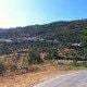 Vista panorâmica da aldeia de Cortiçô com casas dispersas entre oliveiras e pinheiros nas encostas