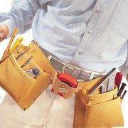 Homem usando cinto amarelo de ferramentas com múltiplos utensílios de trabalho.