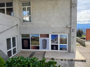 Painéis fotográficos instalados na fachada de edifício com imagens de paisagens, objetos históricos e monumentos