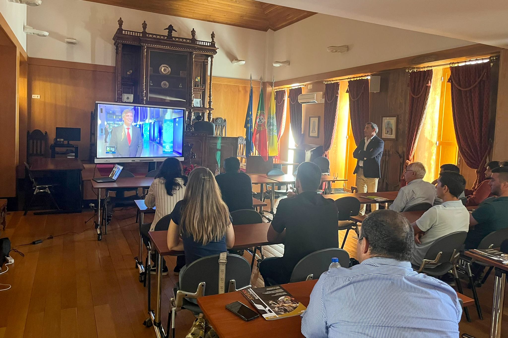 Sala de reunião com participantes a assistir a apresentação em ecrã sobre concurso rural Innovation Challenges
