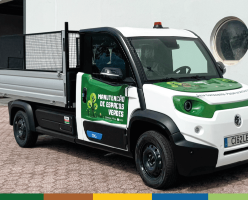 Camião elétrico branco e verde para recolha de biorresíduos com caixa basculante aberta