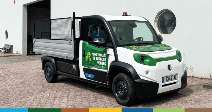 Camião elétrico branco e verde para recolha de biorresíduos com caixa basculante aberta
